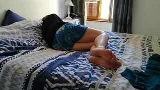 My wife's bare feet on the bed